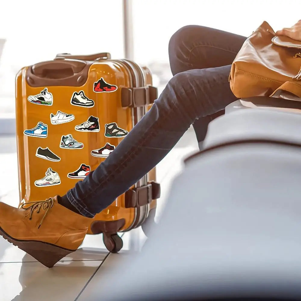 Person with a suitcase featuring shoe designs, sitting on a chair.