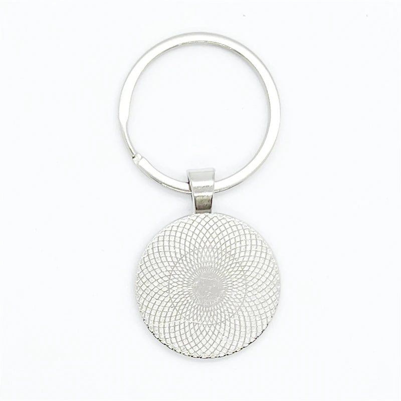 Silver keychain reverse side with a textured circular design on a white background