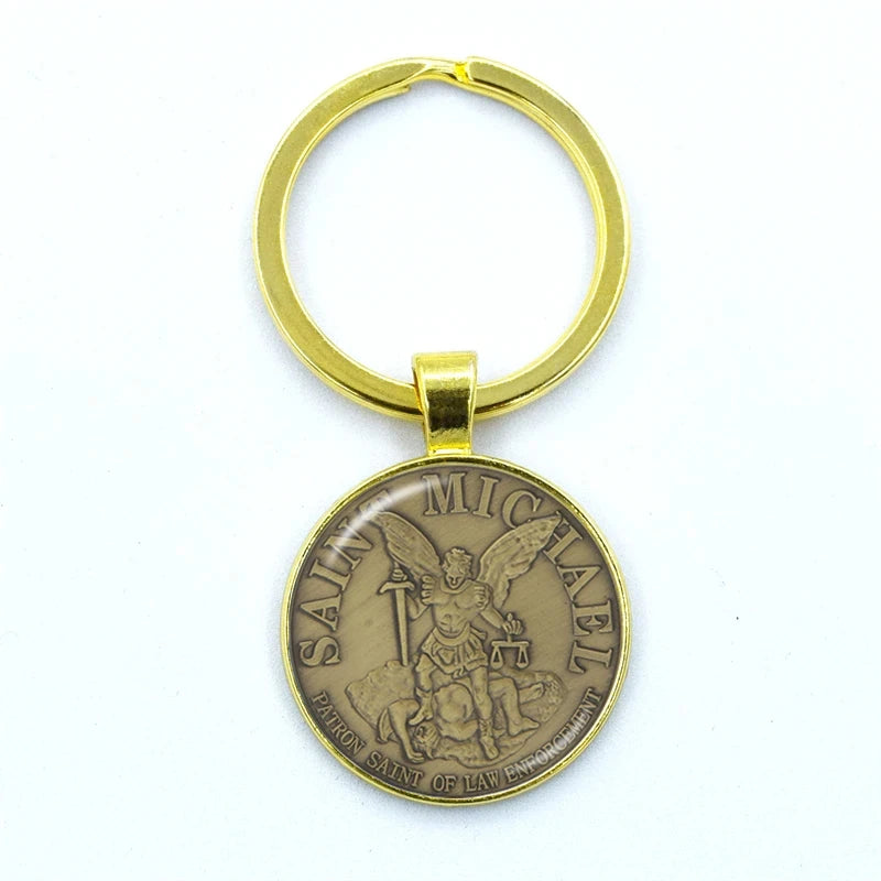 Gold keychain with Saint Michael emblem on a white background