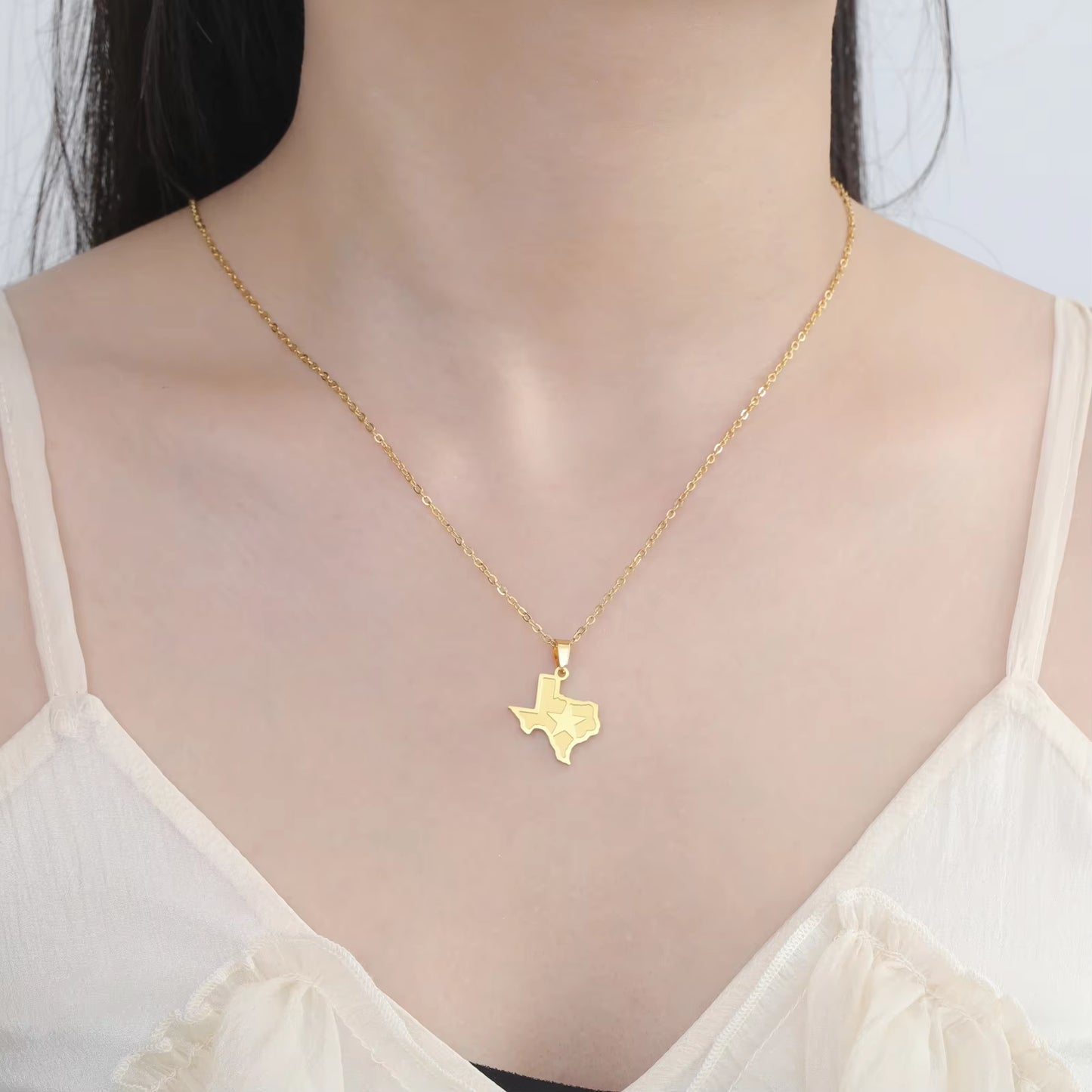 Texas necklace in gold being worn by model across the clavicle showing the fit.