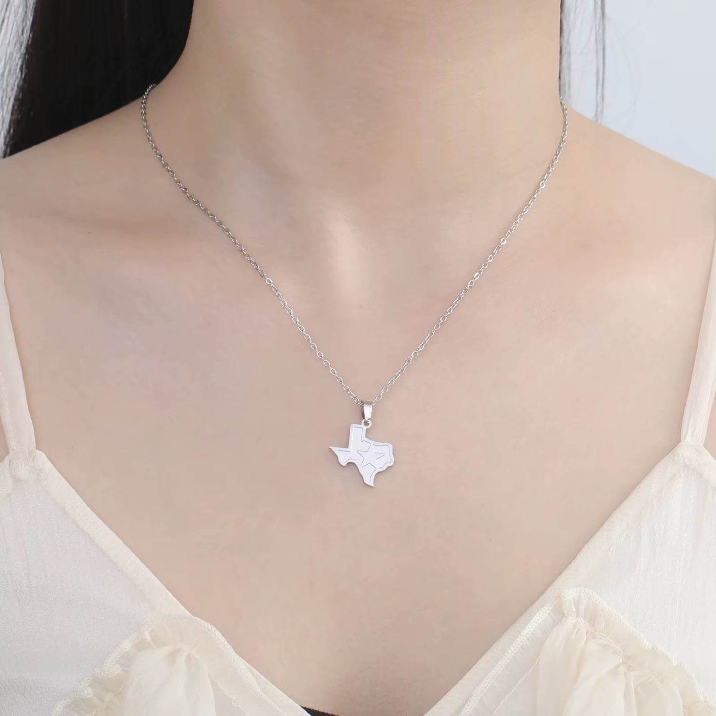 Texas necklace in silver being worn by model across the clavicle showing the fit.