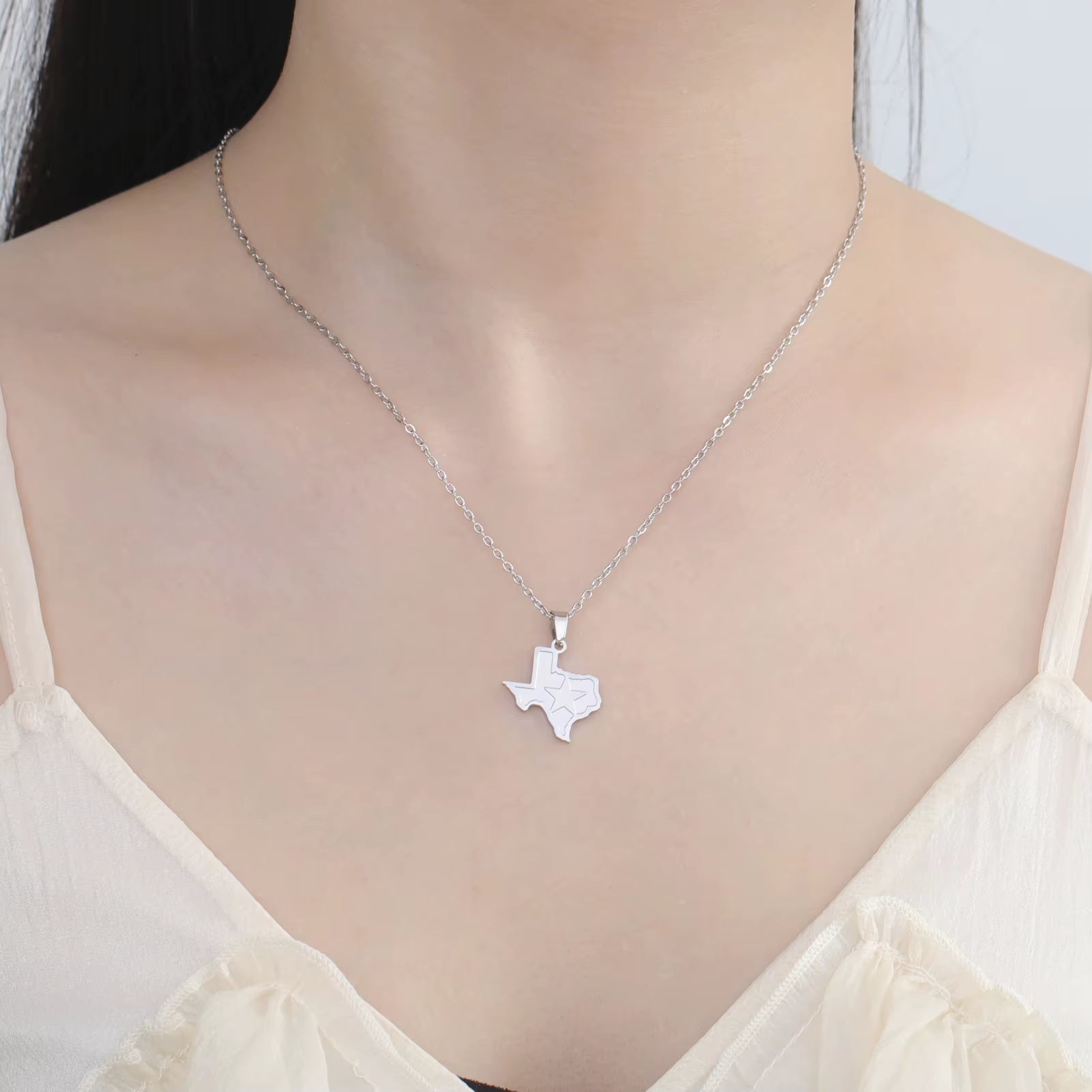 Texas necklace in silver being worn by model across the clavicle showing the fit.