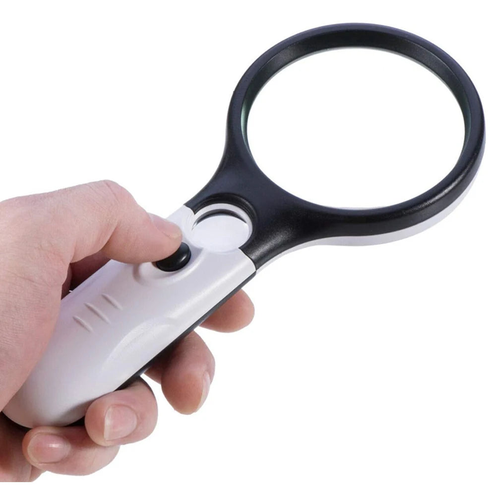 Hand holding a magnifying glass with black and white design on a white background