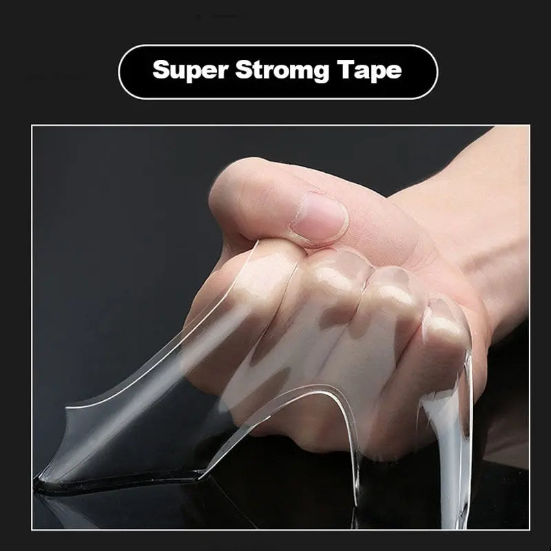 Hand holding a clear strip of super strong tape against a black background