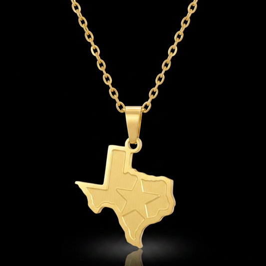 A gold pendant necklace featuring the outline of the state of Texas with an engraved star, suspended from a gold link chain against a solid black background.