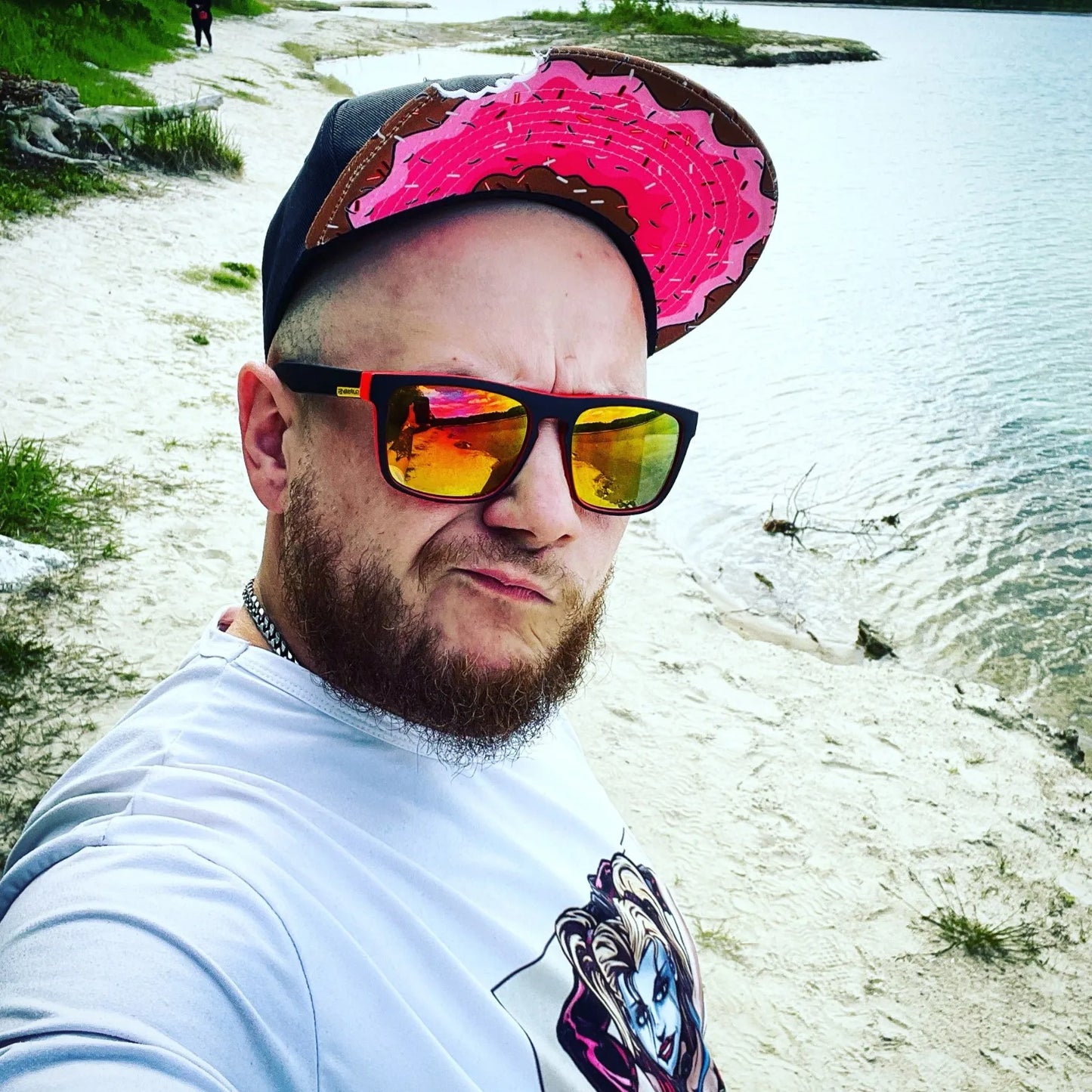 Cool model wearing The Munchies snapback hat with pink sprinkle donut brim and black crown flipped up in trendy fashion headwear, snapback style wear.