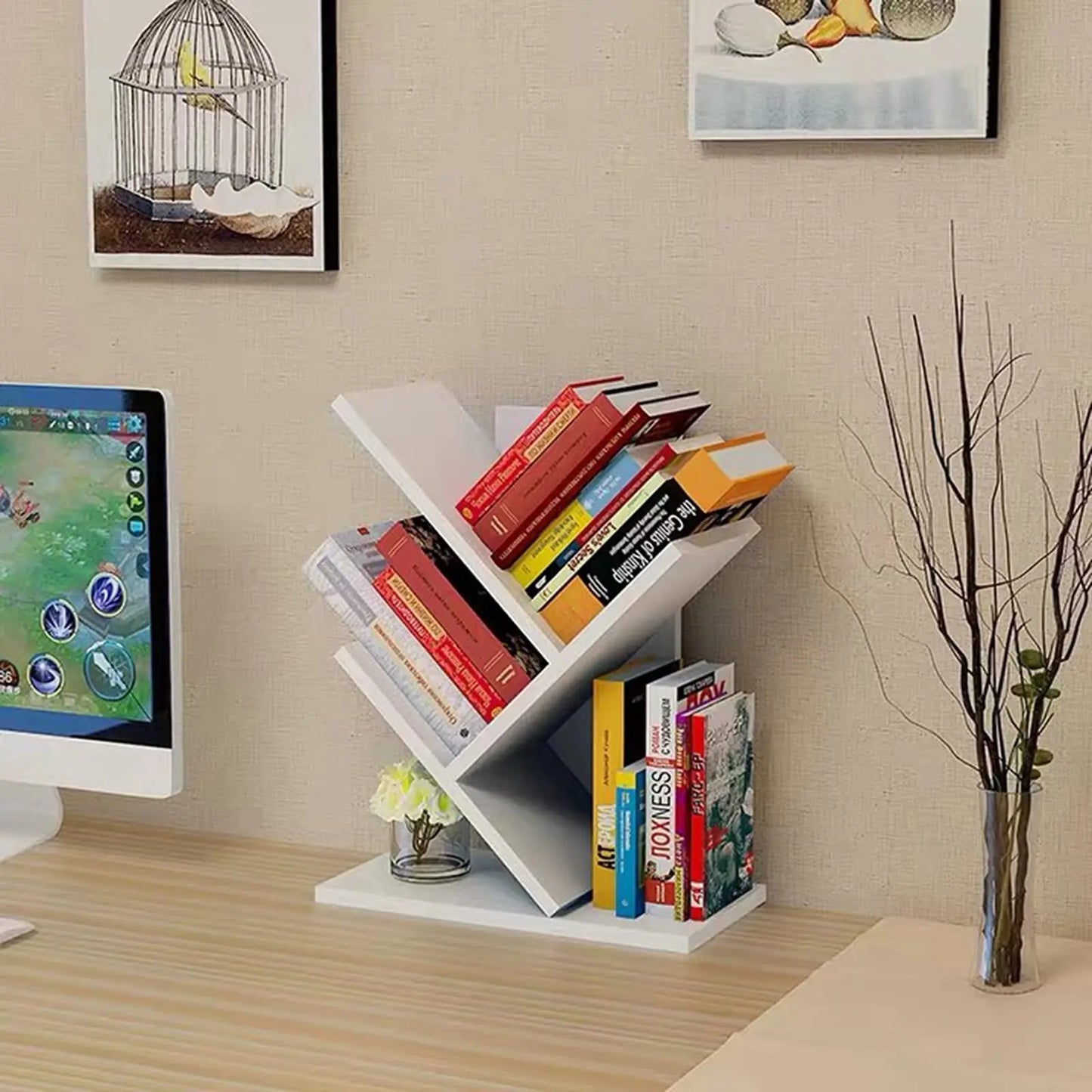 White corner bookshelf with books on a desk next to a computer monitor.