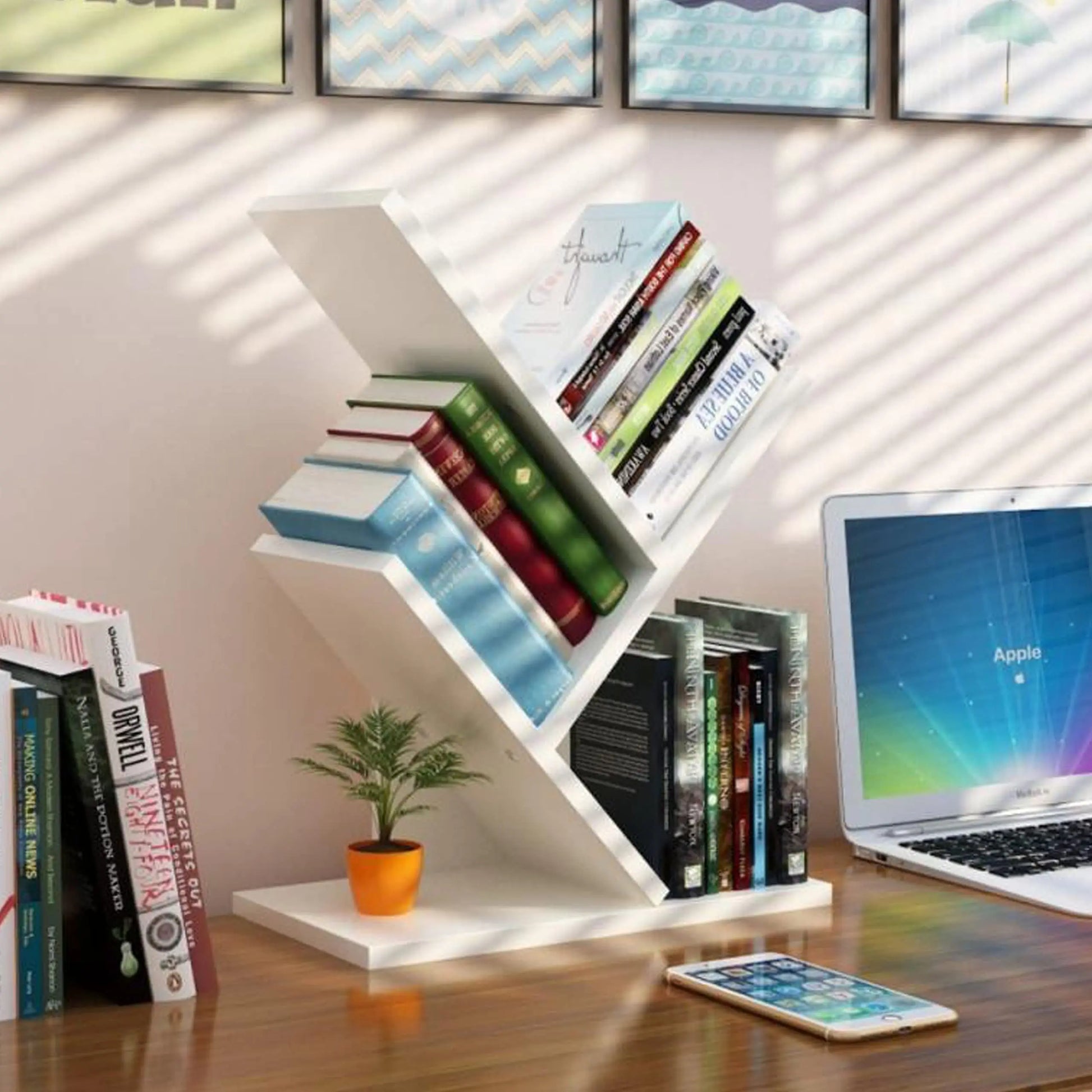 White zigzag bookshelf with books and a laptop on a wooden desk.