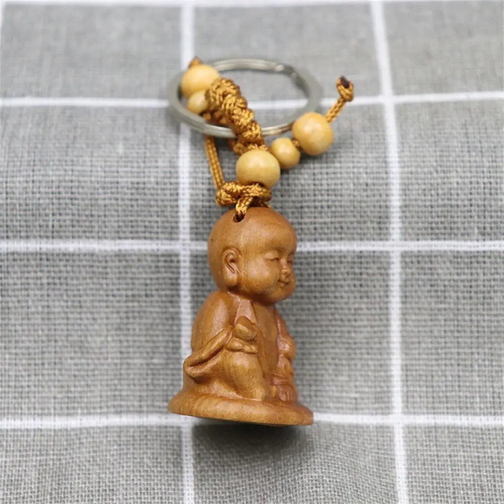 Hand-carved wooden Buddha keychains with prayer and meditation poses