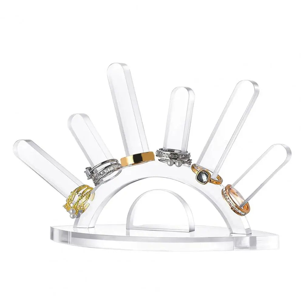 Clear acrylic ring display stand with multiple rings on a white background