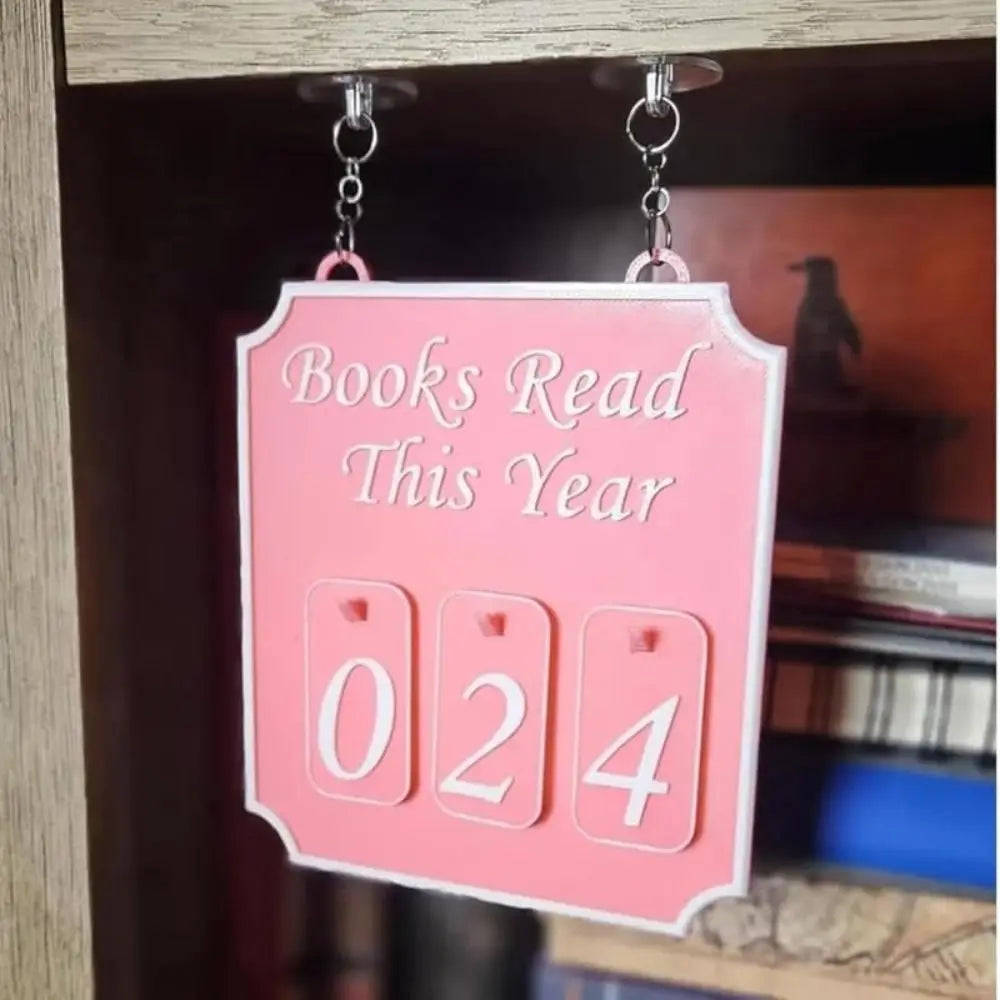 Pink sign with 'Books Read This Year' and numbers '024' hanging on a bookshelf.