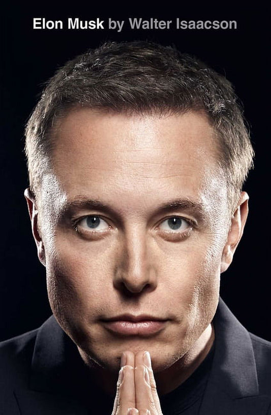 Book front cover of "Elon Musk: A Biography" by Walter Isaacson with a close-up portrait photo of Elon Musk looking into the camera with his hands against his chin and the title text and author at the top of the book cover in white and grey lettering over a black background.